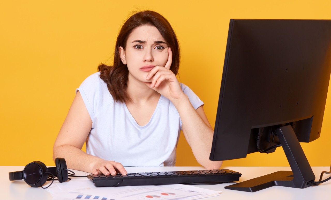 feche-o-retrato-da-jovem-estudante-feminino-usando-computador-desktop-em-uma-biblioteca-da-faculdade